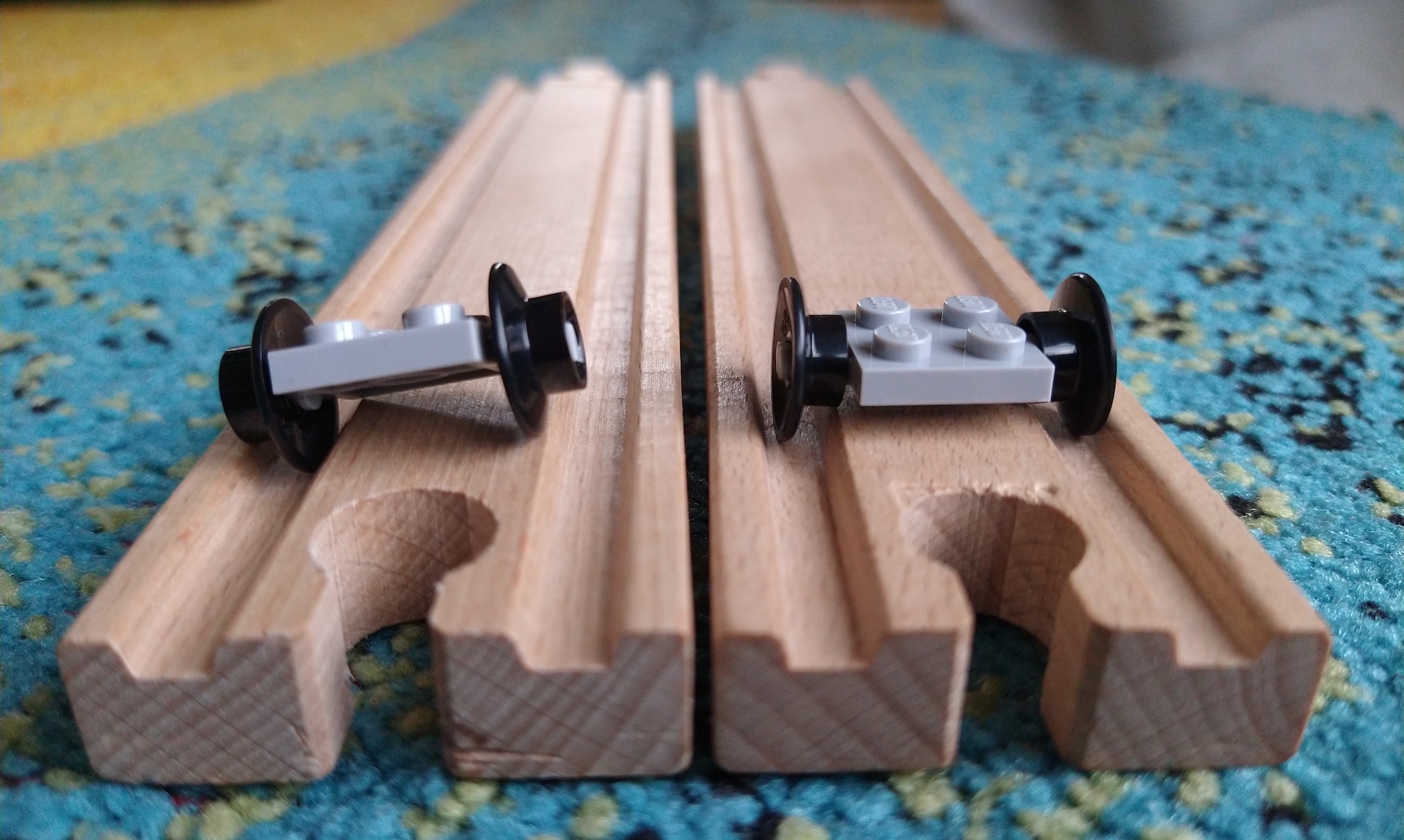 Two sets of Lego wheels on wooden Brio Track